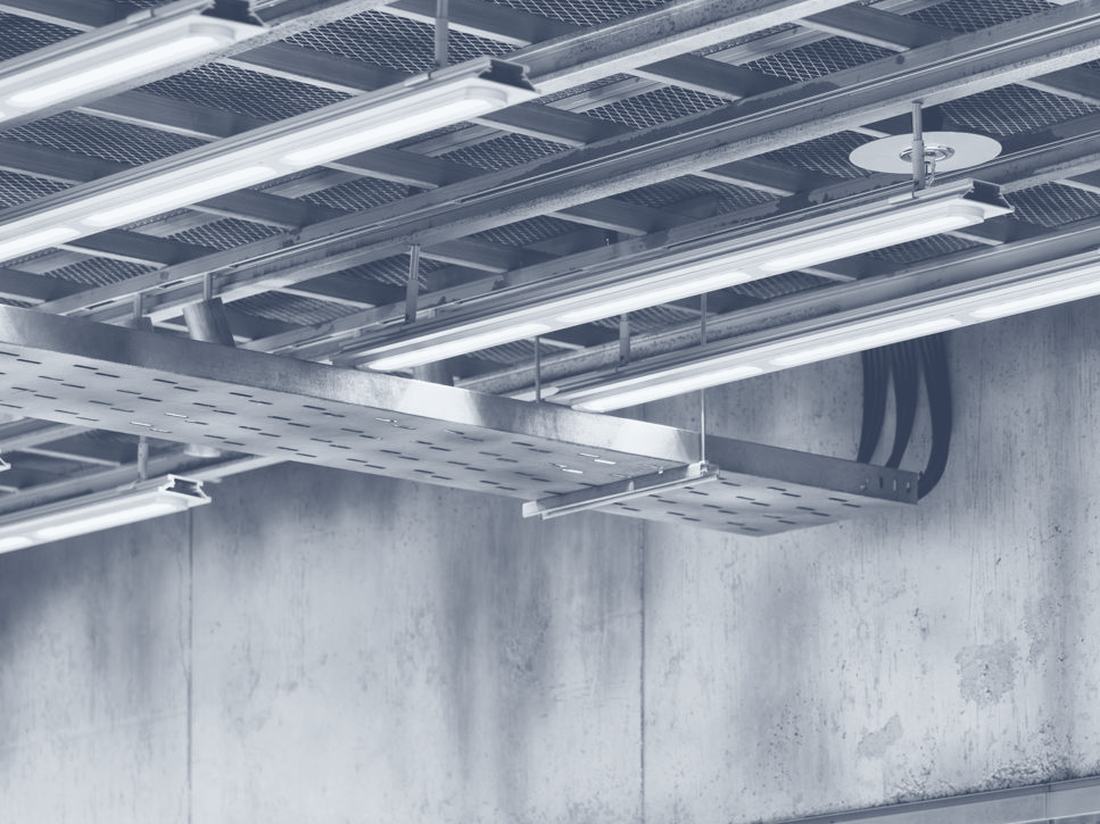 Cable tray and linear lighting under an exposed ceiling